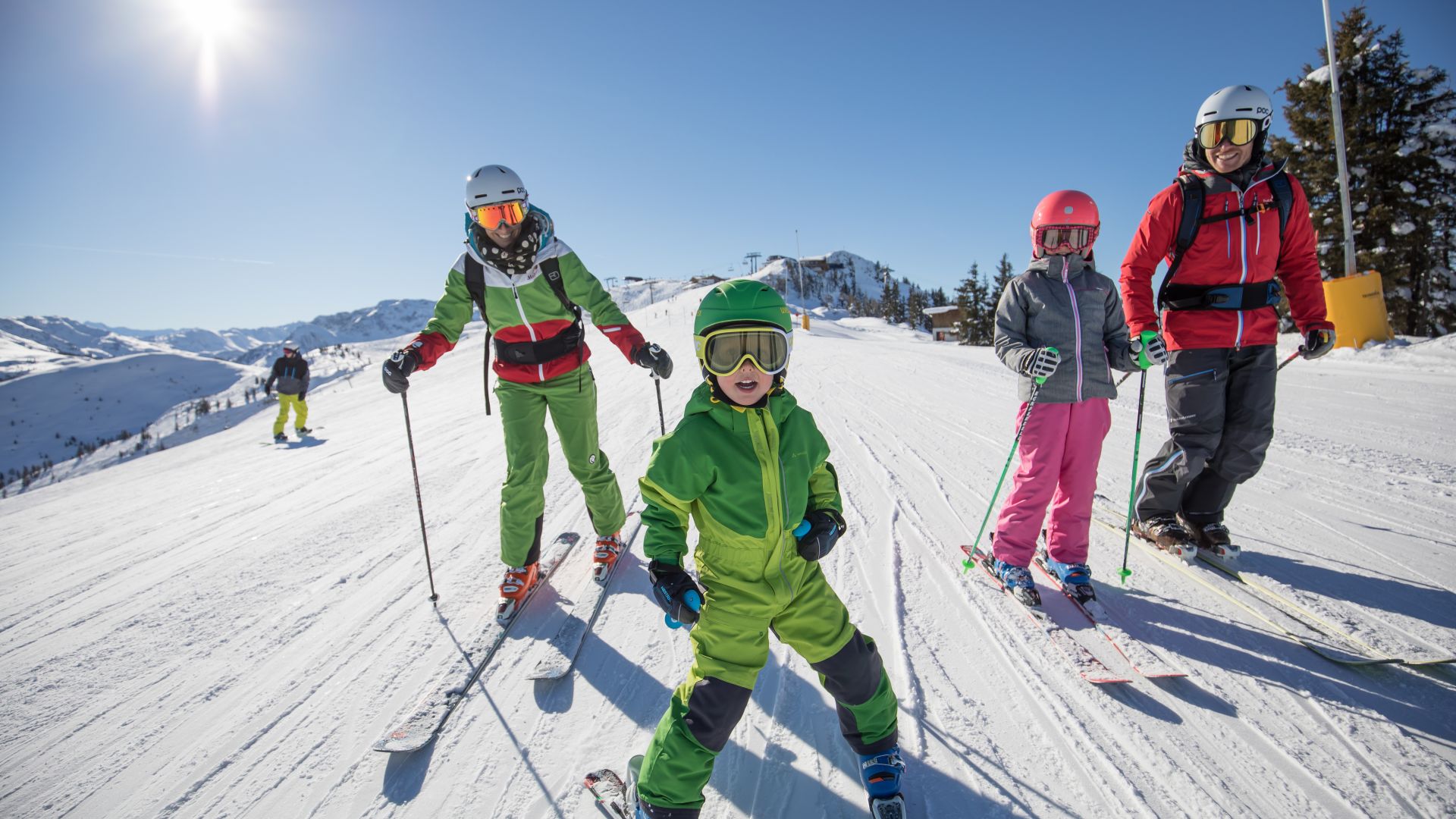 Family with two children skiing on a sunny slope in the Ski Juwel
