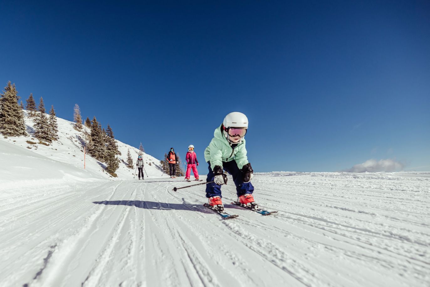 Child skiing happily on a sunny slope in the Ski Juwel